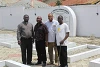 Le Père Michael avec le Père Musa, le Père Raphaël et la victime de l’attentat Vitalis Ugokwe. Dans ce cimetière, les personnes tuées lors de l’attentat sont enterrées. (csi)