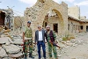 John Eibner avec deux agents de sécurité devant une église détruite à Al-Qaryatayn. (csi)